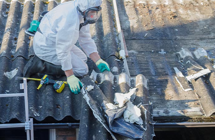 Professional worker removing asbestos from the roof